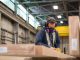 Warehouse workers managing inventory and forklifts in a large Canadian facility